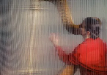 A imagem mostra uma mulher de vermelho tocando harpa.