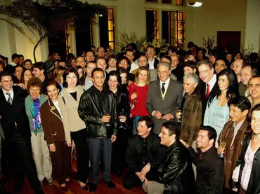 Foto da cerimônia de criação da Fundação Osesp, com músicos da Osesp, o ex-presidente Fernando Henrique Cardoso ao centro e John Neschling, à direita.